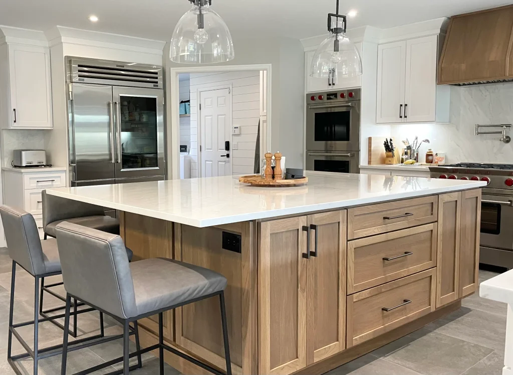 Warm wood kitchen renovation with custom cabinetry, large island, and layered lighting by Avantte Interior Designs
